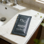 H2O Therapy conditioning shampoo packet with organic aloe vera on bathroom counter
